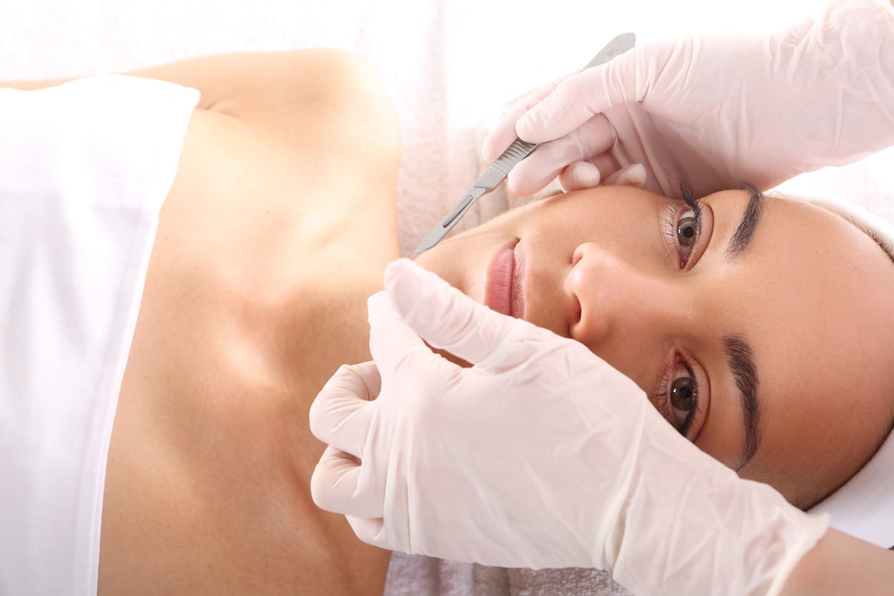 Caucasian woman during surgery using a scalpel